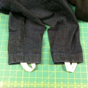 Denim pants right side out with stirrups buttoned into place.